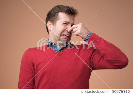 Man plugs nose as smells something stink 50676510