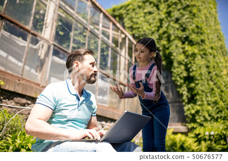 Father with daughter with laptop in park Father with daughter with laptop in park 50676577