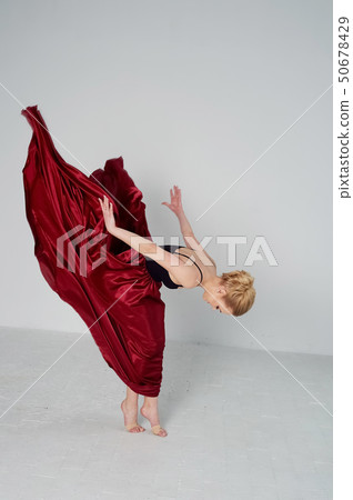 A gymnast in a dark top and a red silk skirt. The color of passion, of aggression.Tango. Plastic A gymnast in a dark top and a red silk skirt. The color of passion, of aggression.Tango. Plastic 50678429