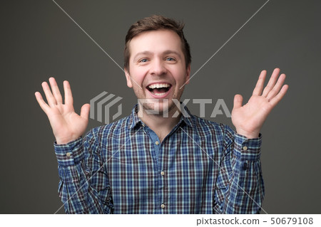 Excited mature man standing with raised hands and looking at camera. Excited mature man standing with raised hands and looking at camera. 50679108