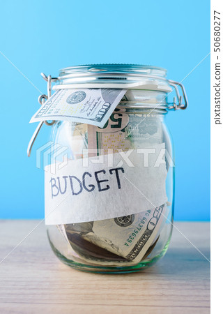 saving bank with dollar bills on a blue background saving bank with dollar bills on a blue background 50680277