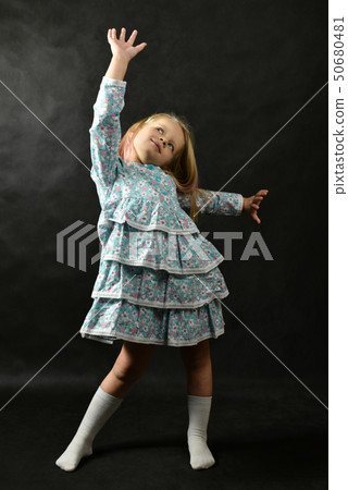 Little girl in a dress standing and dreaming Little girl in a dress standing and dreaming 50680481