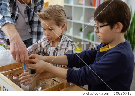 Attentive bearded ginger teacher in clear glasses helping his students 50680713
