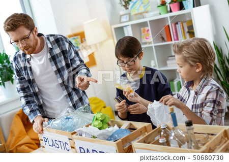 Attentive curious kids sorting out different kinds of trash 50680730
