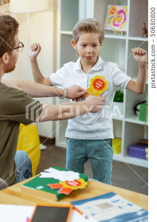 Proud blonde child getting sign for being eco smart kid 50680800