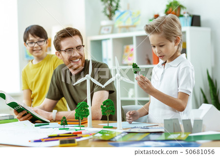 Curious young student carrying plastic example of tree 50681056