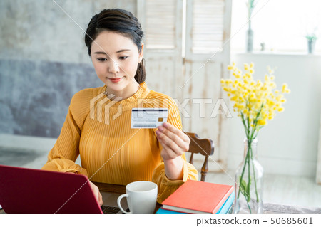 A woman watching a credit card 50685601