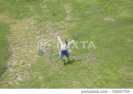 Girl jumping on the grass Girl jumping on the grass 50685704