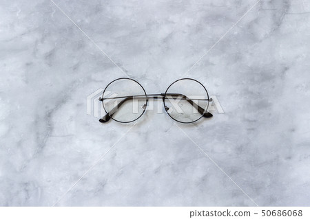 Stylish black round eyeglasses spectacles on marble background. Top view Copy space Minimal style 50686068