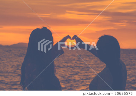 Silhouette woman hand is making a heart-shaped 50686575