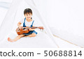 Little kid learning to play a music (guitar)  50688814
