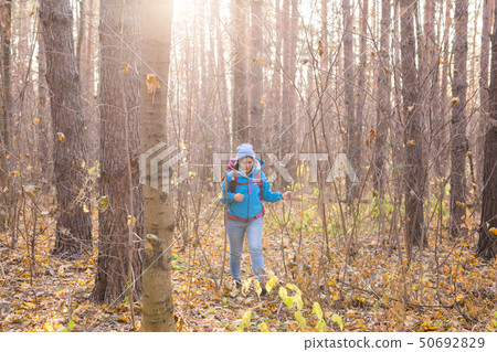 adventure, travel, tourism, hike and people concept - smiling tourist woman walking with backpacks 50692829