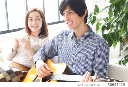 Image of a boyfriend and her girlfriend playing the guitar Image of a boyfriend and her girlfriend playing the guitar 50693429