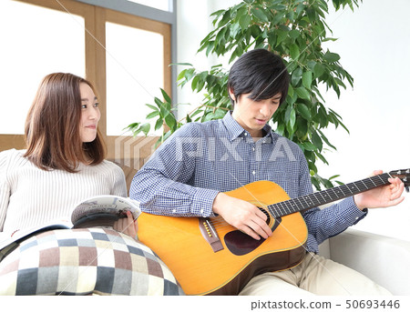 Image of a boyfriend and her girlfriend playing the guitar 50693446