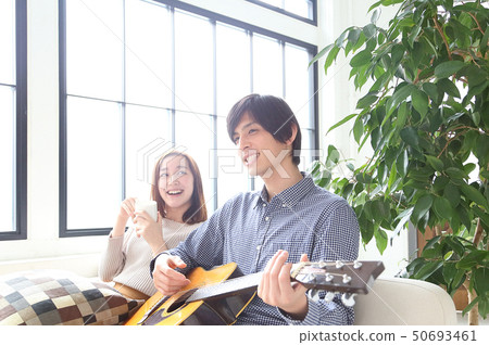 Image of a boyfriend and her girlfriend playing the guitar 50693461