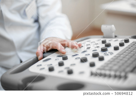 The doctor holds an ultrasound on the patient, a hand close up 50694812