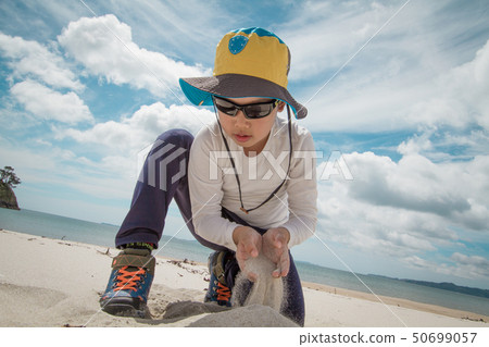 A child playing in the sand at the beach A child playing in the sand at the beach 50699057