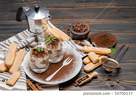 Classic tiramisu dessert in a glass on wooden background Classic tiramisu dessert in a glass on wooden background 50700137