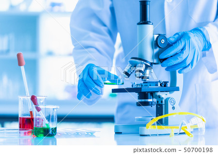 Scientist adjusting microscope for experiment.. 50700198
