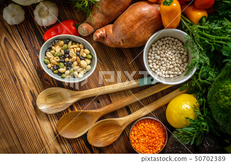 Assortment of fresh vegetables on wooden background Assortment of fresh vegetables on wooden background 50702389