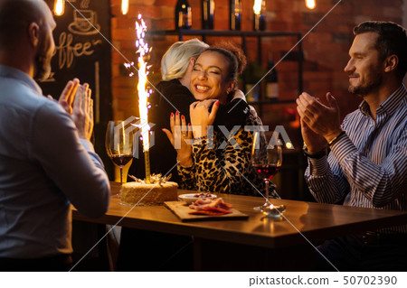 Group of friends celebrating birthday in a cafe behind bar counter Group of friends celebrating birthday in a cafe behind bar counter 50702390