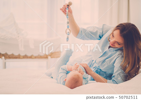 Happy middle aged mother with her child in a bed Happy middle aged mother with her child in a bed 50702511