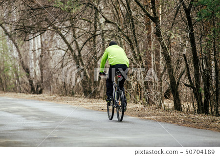 back cyclist in bright jacket riding back cyclist in bright jacket riding 50704189