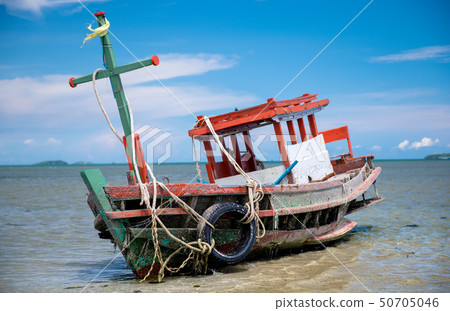 Wreck wooden fishery boat on the beach. 50705046