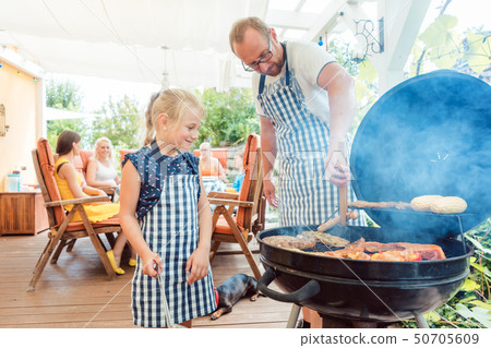 Dad and kid doing the barbeque at the grill Dad and kid doing the barbeque at the grill 50705609