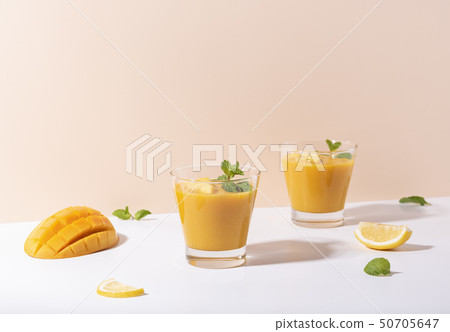 Fresh mango smoothie and ripe mango slice on color Fresh mango smoothie and ripe mango slice on color 50705647