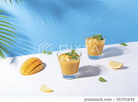 Fresh mango smoothie and ripe mango slice on color Fresh mango smoothie and ripe mango slice on color 50705648