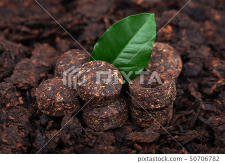 Aromatic black pu-erh tea. Fermented and compressed Leaves into bricks. Round flat disc of puer tea Aromatic black pu-erh tea. Fermented and compressed Leaves into bricks. Round flat disc of puer tea 50706782