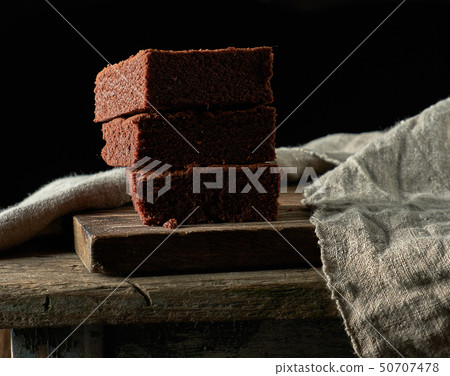 stack of baked square pieces of chocolate brownie stack of baked square pieces of chocolate brownie 50707478