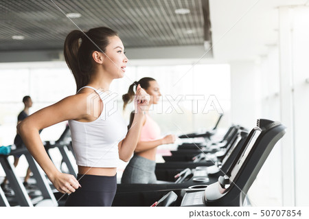 Asian girl working out on treadmill at the gym Asian girl working out on treadmill at the gym 50707854