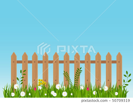 A wooden fence, a hedge near with a flower bed. 50709319