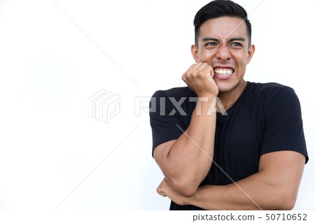 Young man holding hand on his cheek while standing on white background. Young man holding hand on his cheek while standing on white background. 50710652