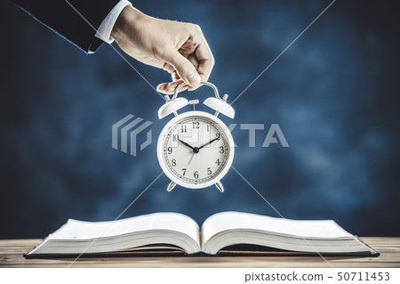 Person's hand with alarm clock 50711453