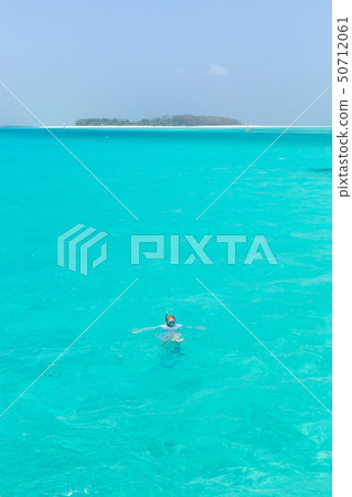 Woman snorkeling in clear shallow sea of tropical lagoon with turquoise blue water. 50712061