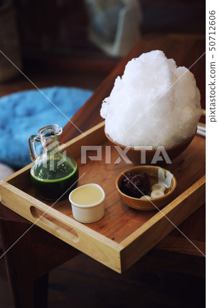 Delicious Japanese sweet shaved ice green tea on wooden table in japanese cafe Delicious Japanese sweet shaved ice green tea on wooden table in japanese cafe 50712606