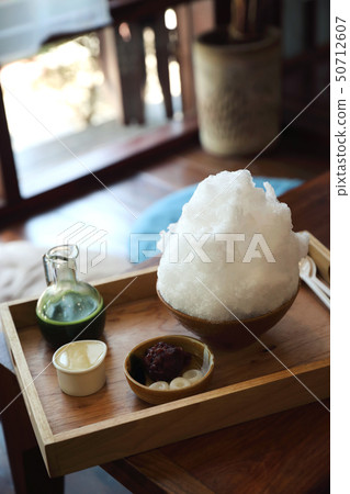 Delicious Japanese sweet shaved ice green tea on wooden table in japanese cafe Delicious Japanese sweet shaved ice green tea on wooden table in japanese cafe 50712607
