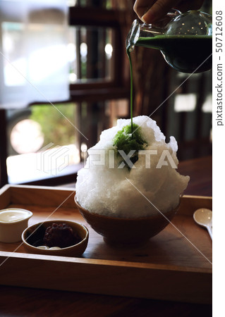 Delicious Japanese sweet shaved ice green tea on wooden table in japanese cafe Delicious Japanese sweet shaved ice green tea on wooden table in japanese cafe 50712608
