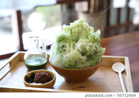 Delicious Japanese sweet shaved ice green tea on wooden table in japanese cafe Delicious Japanese sweet shaved ice green tea on wooden table in japanese cafe 50712609