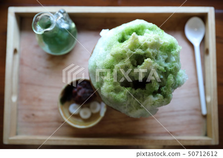 Delicious Japanese sweet shaved ice green tea on wooden table in japanese cafe 50712612