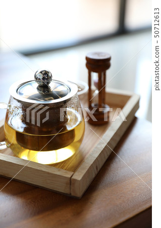 Hot teacup with teapot beverage on wooden table 50712613