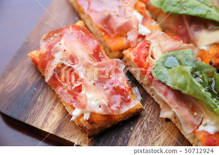 Pizza with parma ham salad rocket and parmesan on dark wooden background close up. Italian food Pizza with parma ham salad rocket and parmesan on dark wooden background close up. Italian food 50712924