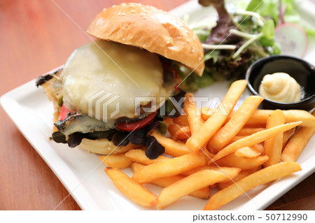 Beef Hamburger with fries and salad on wooden background 50712990