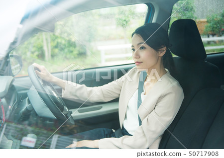 A woman driving a car 50717908