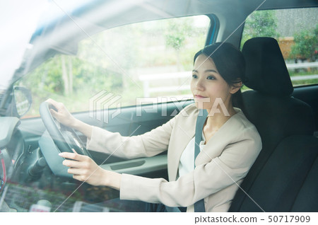 A woman driving a car 50717909
