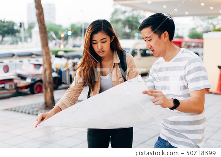 Young Asian couple with map on street Young Asian couple with map on street 50718399