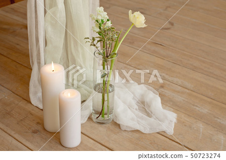 Branch of blooming white peony tulip Mattiola branch in a glass vase white wax candles stand on the Branch of blooming white peony tulip Mattiola branch in a glass vase white wax candles stand on the 50723274
